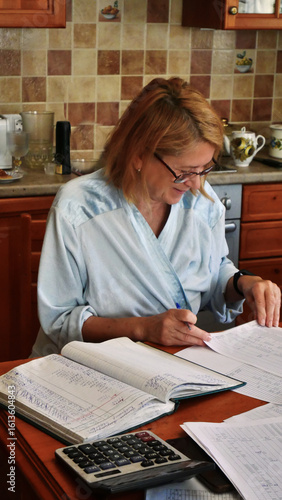Woman Managing Home Finances with Ledger and Calculator