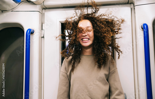Woman with wind swept hair traveling in subway train