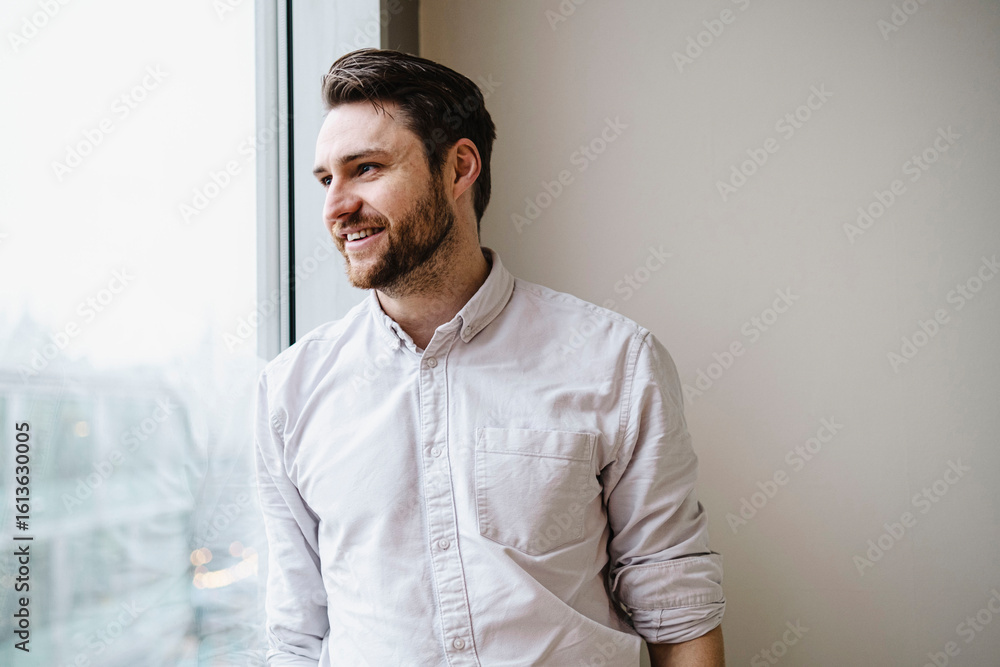 Happy businessman leaning and looking through glass window Happy businessman leaning and looking through glass window