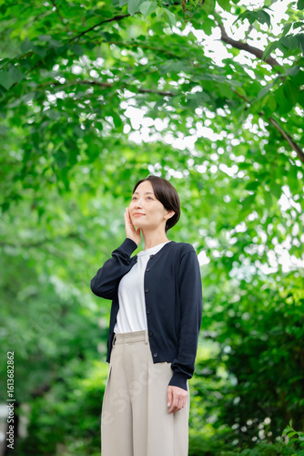 新緑の中に立つ女性