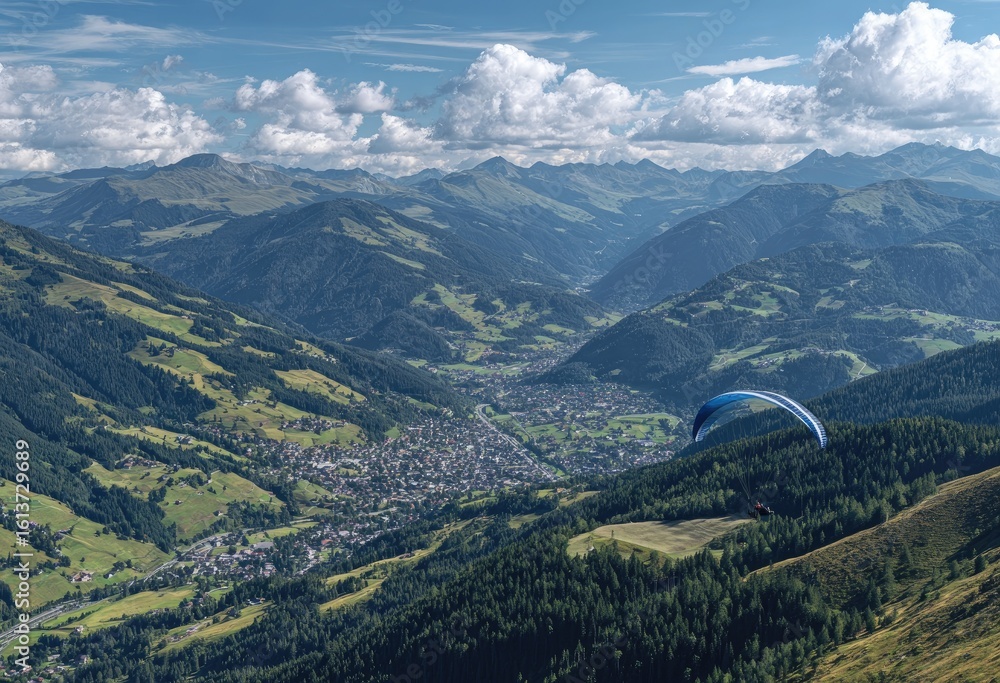 Fototapeta premium Mountain valley vista with paraglider