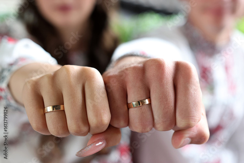 Fotografia The hands of the newlyweds with wedding rings are clenched into fists