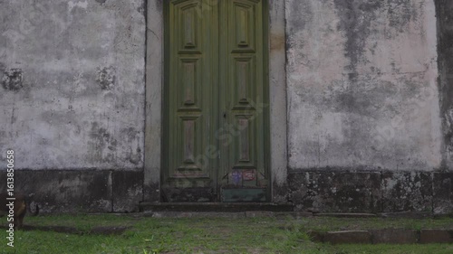 Old historical door of church, dog walking by