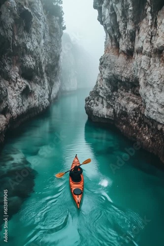 Solo Kayaker Paddling Through Turquoise Canyon in Morning Fog