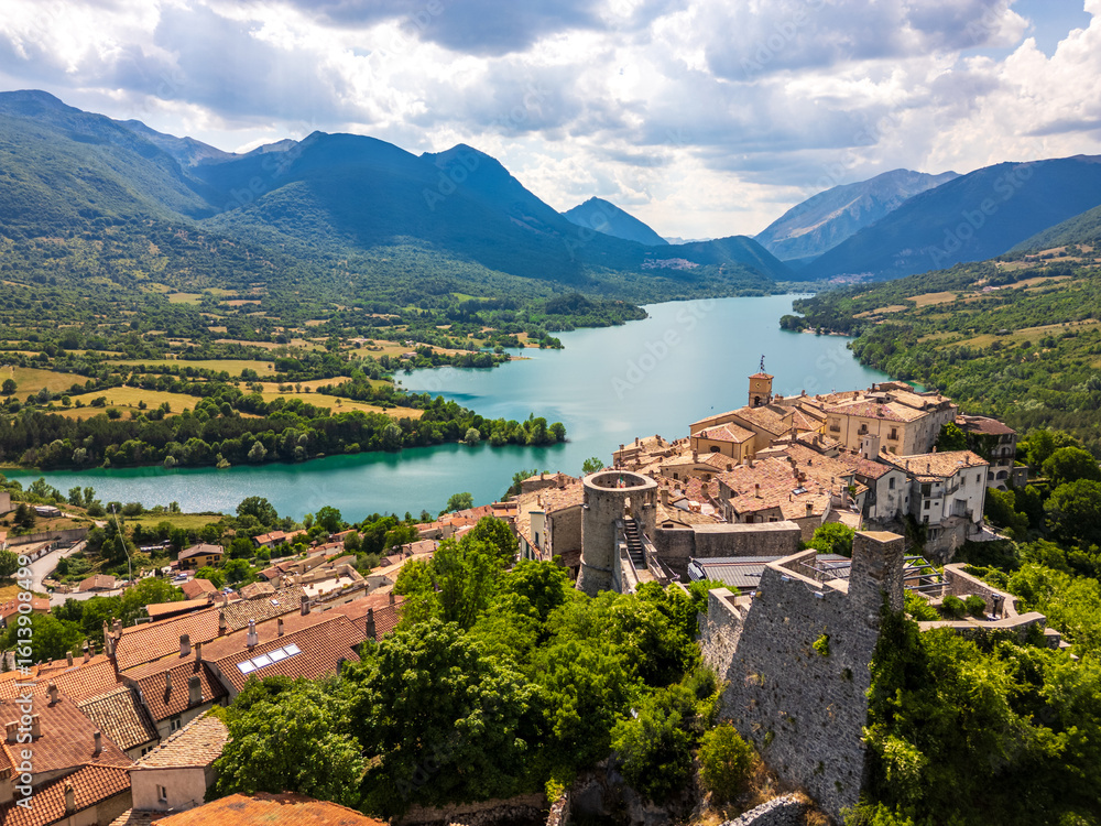 Obraz premium Aerial drone view of the medieval village of Barrea with its magnificent lake in the province of L'Aquila, Abruzzo. This place exudes history, peace, and tranquility.