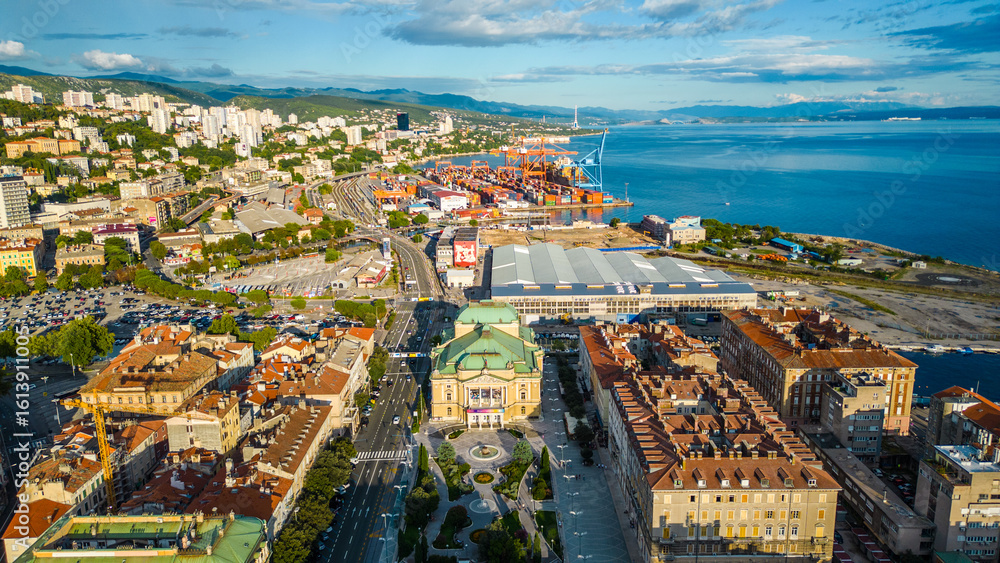 Fototapeta premium Rijeka city center and waterfront aerial view at sunset, panoramic view of the Kvarner Gulf in Croatia. Scenic harbor with boats, historic architecture, container terminal, canals, seafront promenade