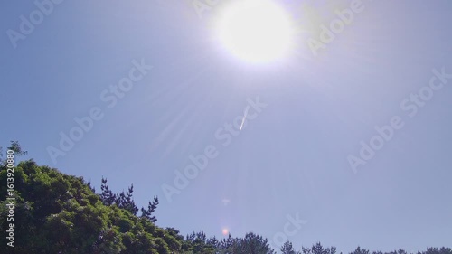 飛行機雲と太陽、夏の青空
