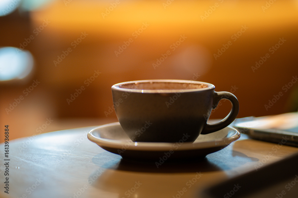 Obraz premium Side view of hot latte coffee a black cup on wooden table.