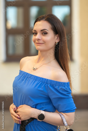 Portrait of a young beautiful long-haired girl in a blue dress in an urban environment in summer. Free Download Portrait of a young beautiful long-haired girl in a blue dress in an urban environment in summer. - GFXLoad