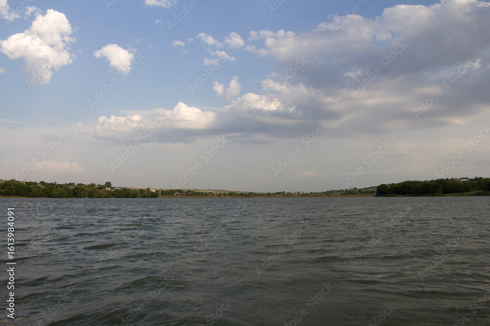 Obraz premium A body of water with trees in the background