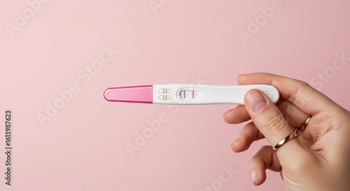 Hand holding a positive pregnancy test
