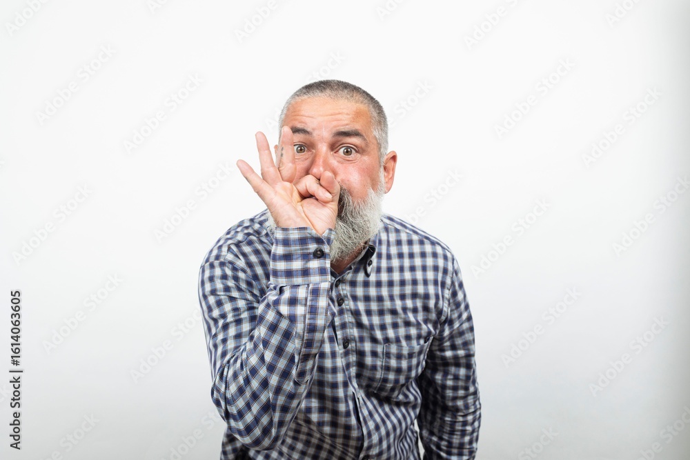Bearded senior man making ok sign covering mouth showing approval sign Bearded senior man making ok sign covering mouth showing approval sign