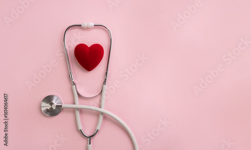 White stethoscope and red decorative heart on pink background. Medical calendar or banner for cardiology hospital or clinic. Selective focus, copy space