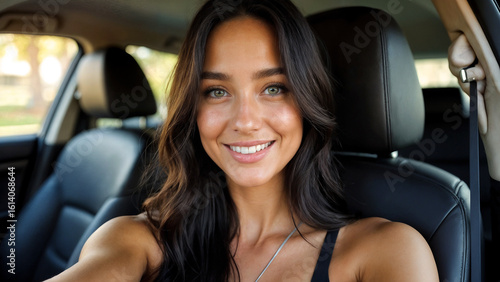 young beautiful woman taking selfie in car