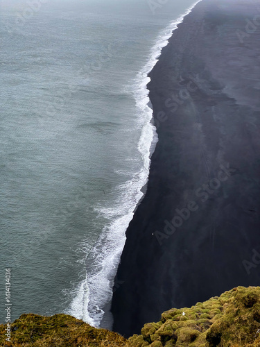 Scenic view from the cliffs above Dyrhólaey Beach, Iceland, with dramatic black sand shoreline