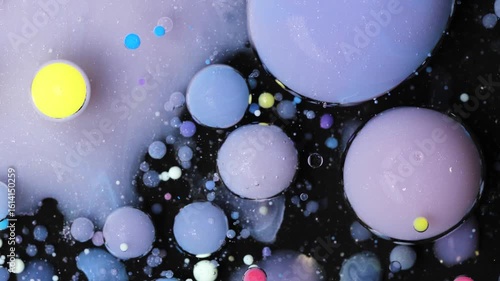 Vibrant acrylic paint droplets suspended in oil create a mesmerizing abstract flow