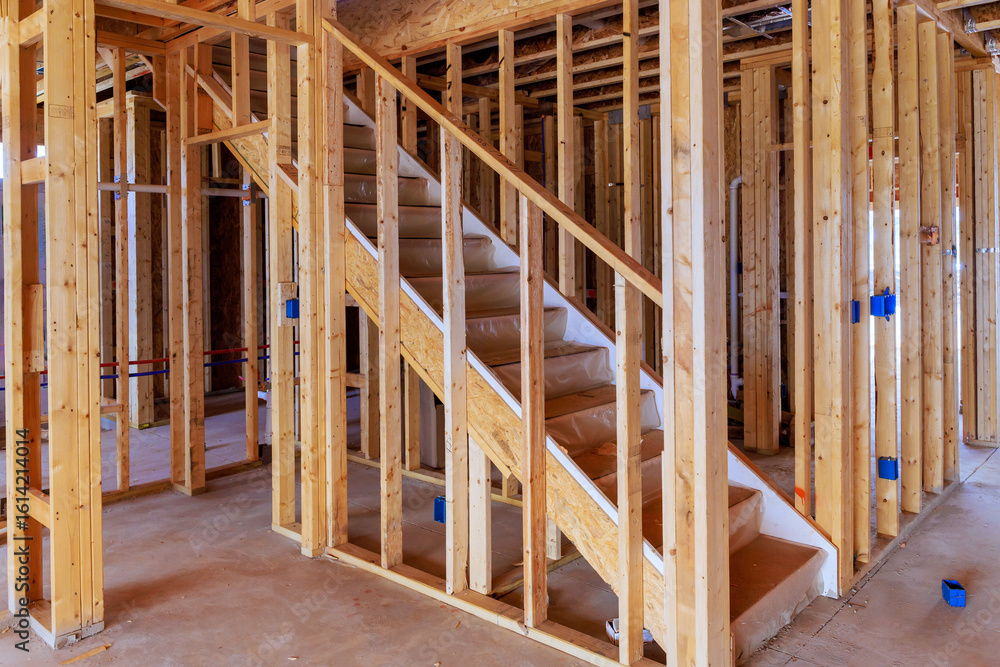 Wooden staircase leading to upper floors being built within framework of new home works area Wooden staircase leading to upper floors being built within framework of new home works area