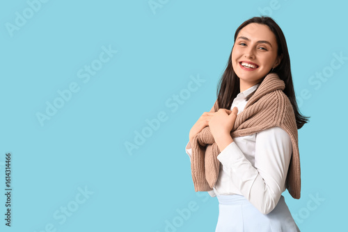 Smiling young woman on blue...