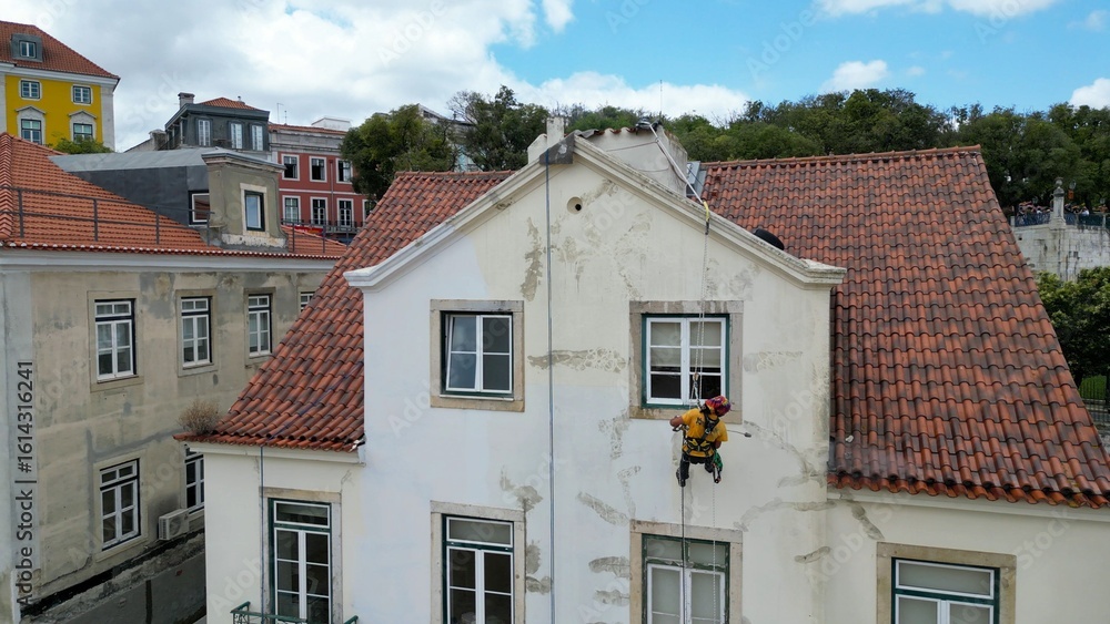 Fototapeta premium Aerial view of a climber painting a building
