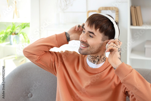 Young tattooed man in headp...