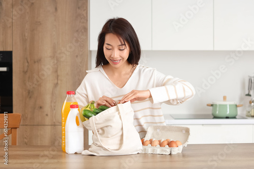 Young Asian woman unpacking...