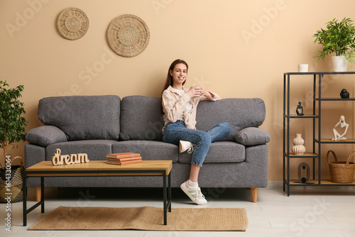 Young woman holding cup and...
