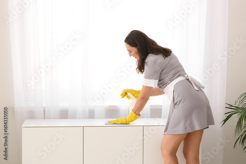 Young chambermaid cleaning ...