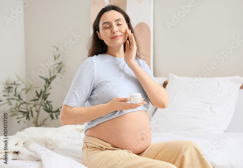 Young pregnant woman applyi...