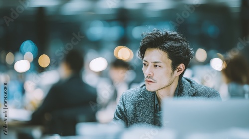 a 28-year-old Japanese business people working in an office while looking at a PC, a smartphone on the desk