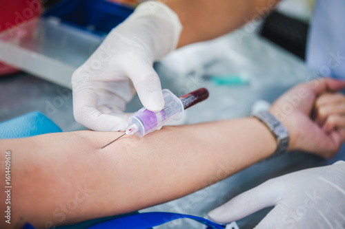 Close up hand of nurse, taking blood sample from a patient in the hospital.	