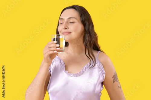 Young woman in pajamas drin...