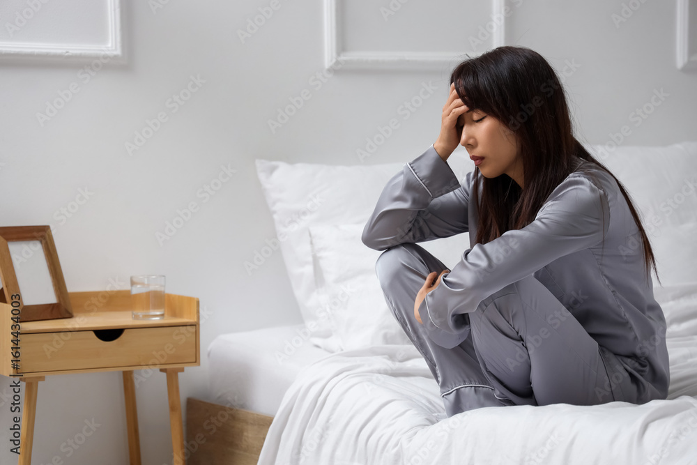 Young Asian woman with suicidal thoughts sitting in bedroom Young Asian woman with suicidal thoughts sitting in bedroom
