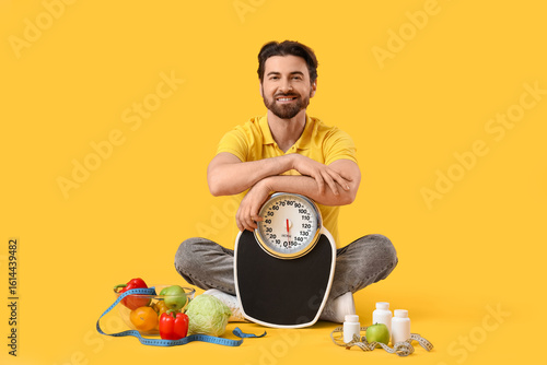 Young man with weight scale...