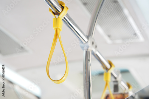 Yellow hanging strap inside a bus during daytime commute