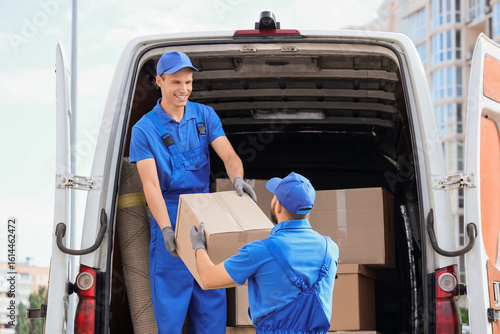 Male movers unloading box f...