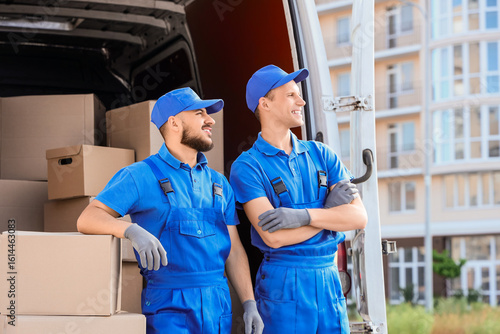Male movers with boxes near...