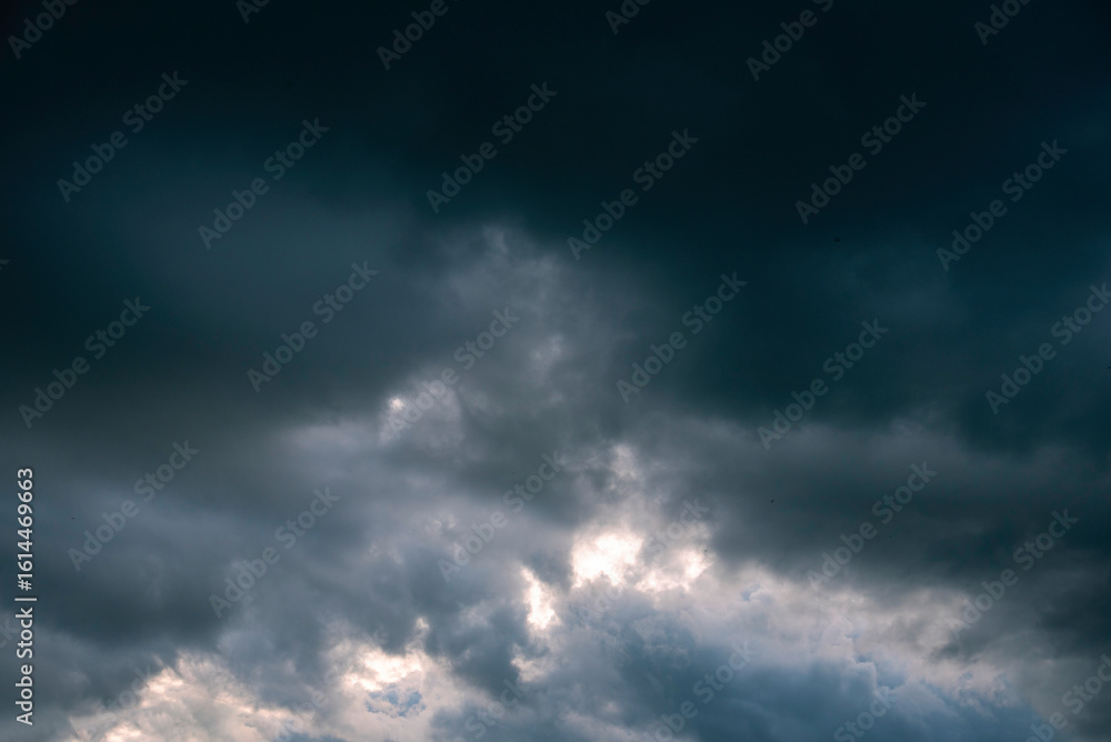 Fototapeta premium Dramatic dark storm rain clouds black sky background. Dark thunderstorm clouds rainny atmosphere. Meteorology danger windstorm disasters climate. Dark cloudscape storm disaster gloomy gray cloud sky