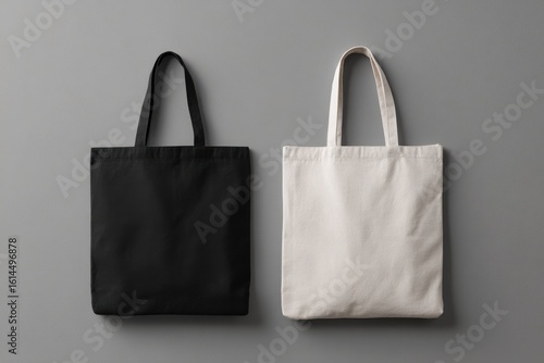 Two blank tote bags, black and beige, on gray background