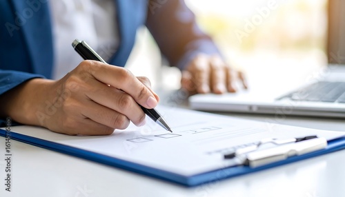 Businesswoman completing paperwork at desk
