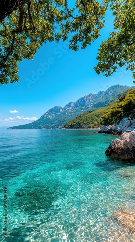 Serene Coastal Landscape with Crystal Clear Water and Lush Green Mountains