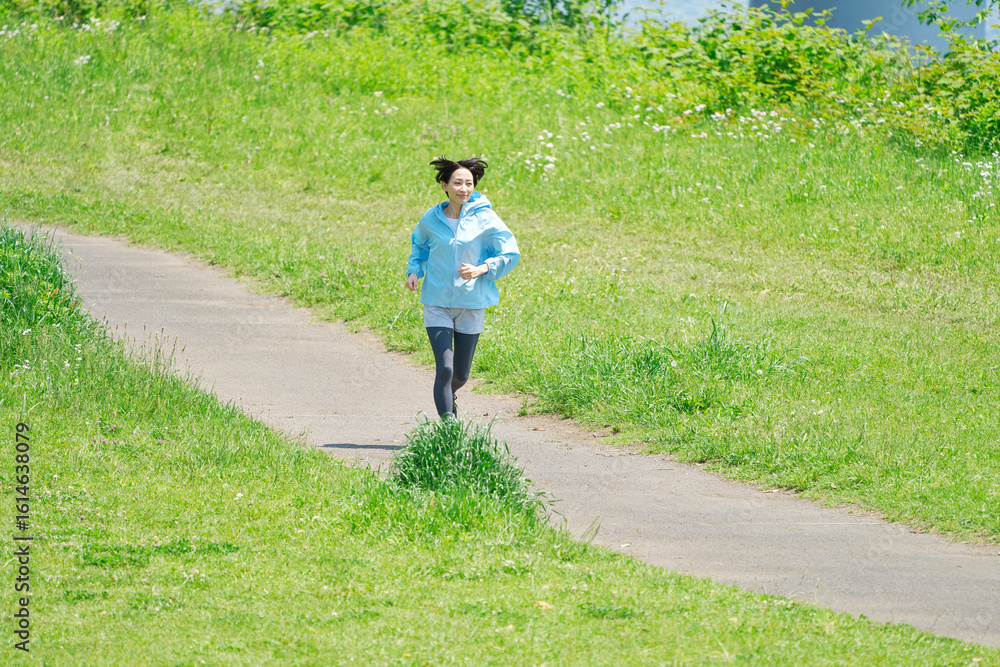 Fototapeta premium 屋外でランニングする40代女性 全身