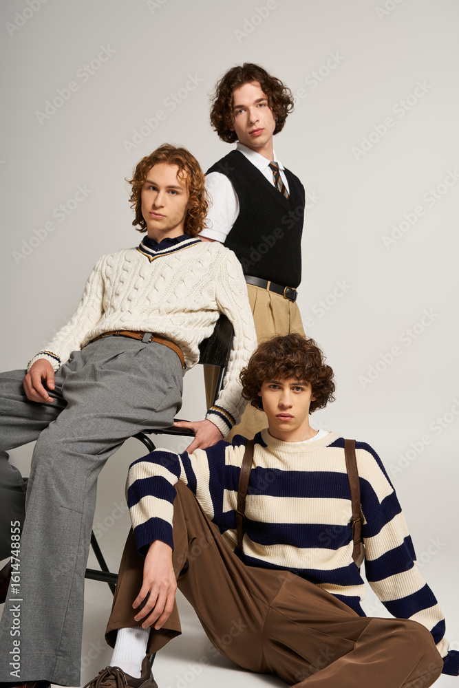 Obraz premium Young stylish friends showcase contemporary fashion in a modern studio setting