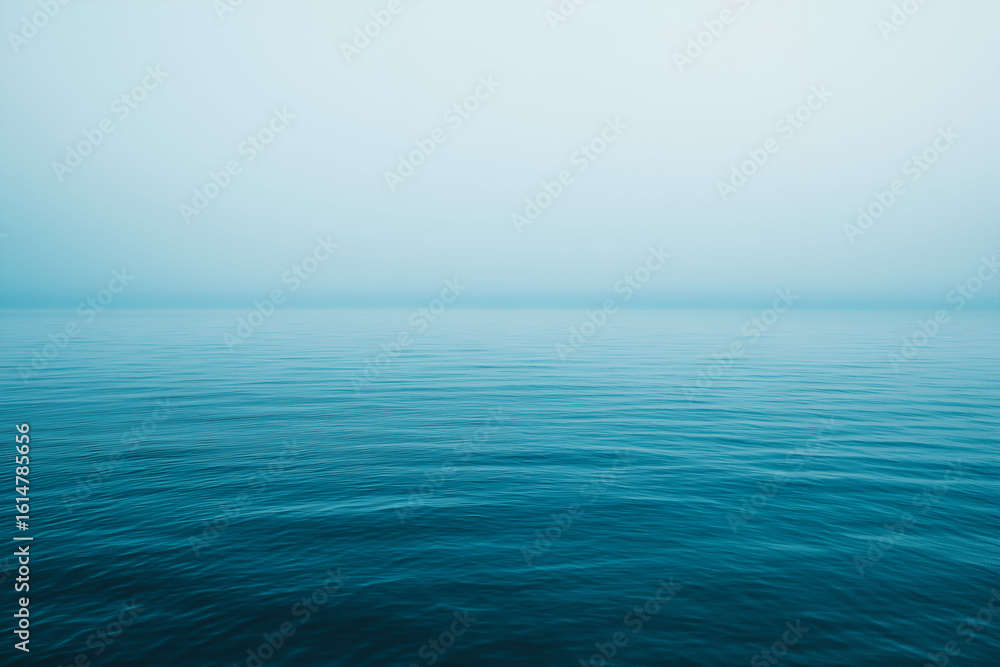 Obraz premium Serene Seascape with Calm Water on a Foggy Morning.