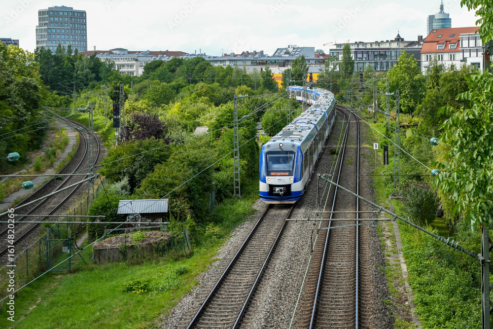Naklejka premium A blue and white Bayerische Regiobahn (BRB) train on its journey in the Sendling district. The BRB connects Munich with recreational areas in the region.