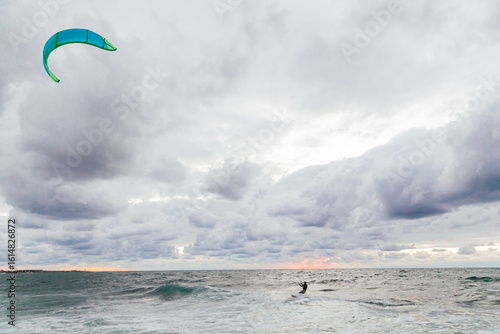 Kite surfing athlete riding waves in storm