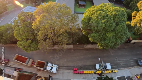 Timelapse of a busy neighborhood street with cars passing by and a truck carrying earth from nearby construction