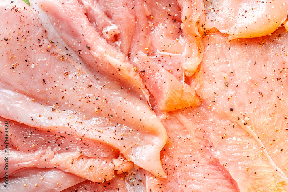 Raw chicken fillet marinated with seasonings close-up. Background with the texture of raw chicken meat. The process of making cordon bleu. Raw chicken fillet marinated with seasonings close-up. Background with the texture of raw chicken meat. The process of making cordon bleu.