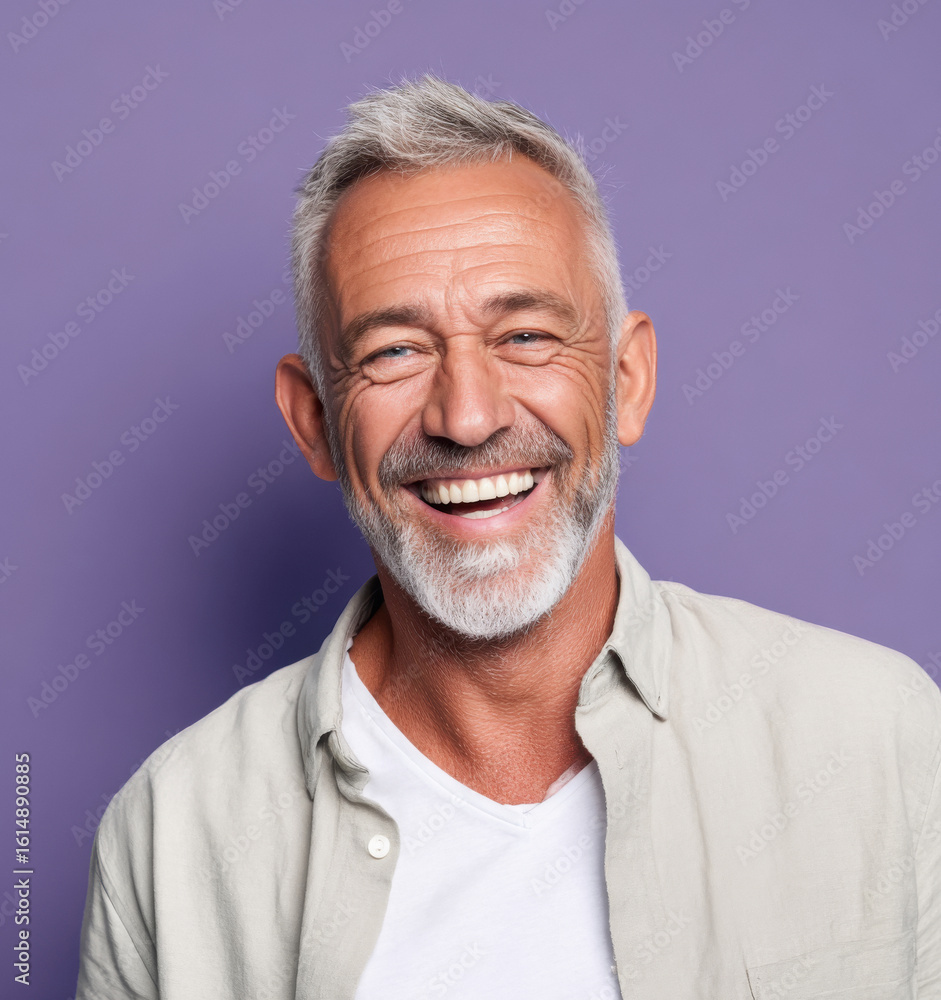 Obraz premium middle aged smiling man standing against purple background