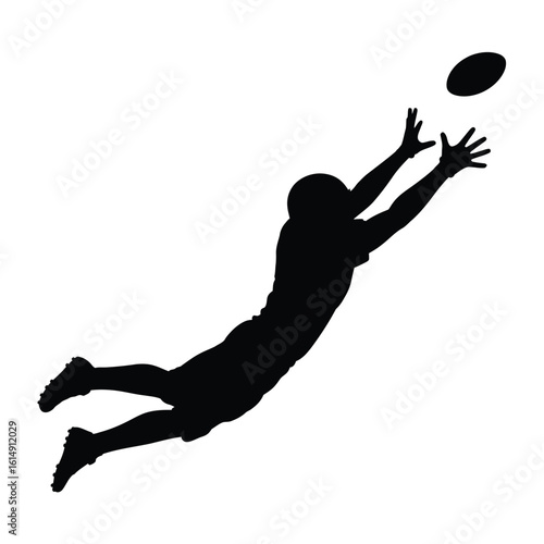 Silhouette of a football player making a diving catch