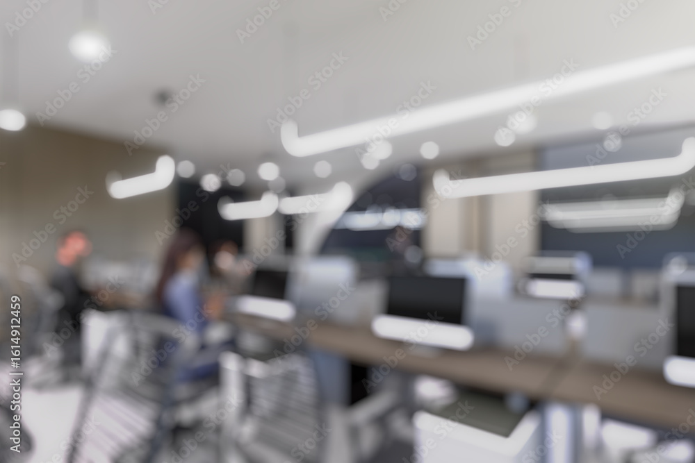 Fototapeta premium Blurred modern office interior with open space design. Rows of workstations and minimalistic lighting fixtures create a contemporary business environment.
